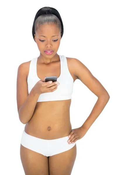 Concentrated woman in sportswear texting — Stock Photo, Image