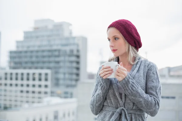 Thinking gorgeous blonde drinking coffee outdoors — Stock Photo, Image