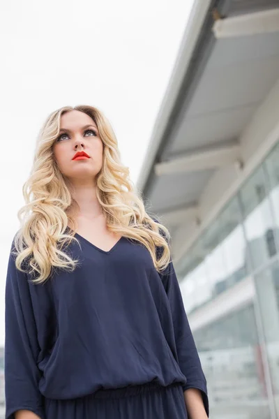Unsmiling gorgeous blonde with red lips posing outdoors — Stock Photo, Image