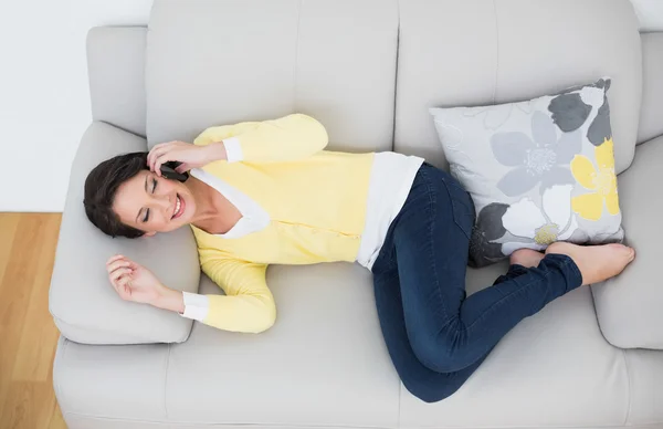 Brune occasionnelle joyeuse en cardigan jaune faisant un appel téléphonique — Photo