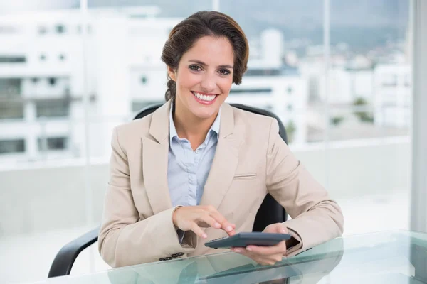 Glimlachende zakenvrouw met behulp van calculator — Stockfoto