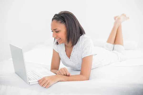 Delighted young model using a laptop — Stock Photo, Image
