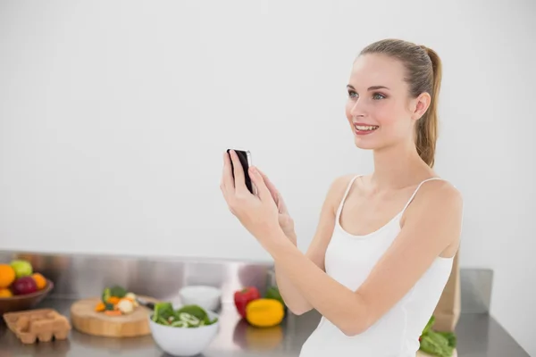 Fröhliche junge Frau schickt eine SMS — Stockfoto