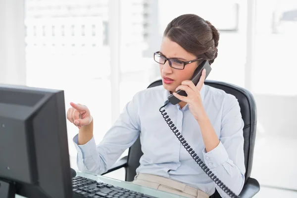 Donna d'affari accigliata che risponde al telefono — Foto Stock