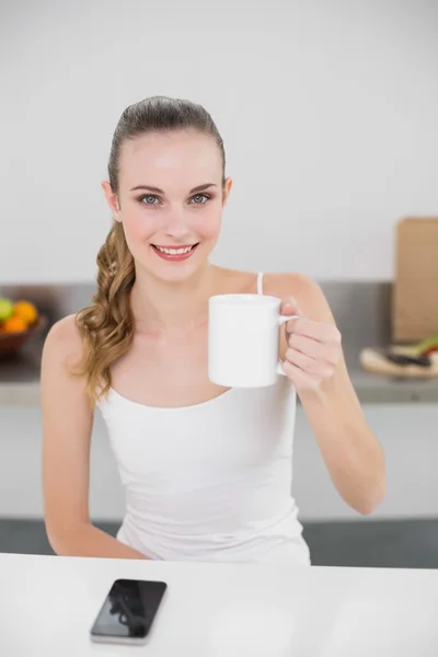 Glückliche junge Frau mit einem Becher in der Hand — Stockfoto