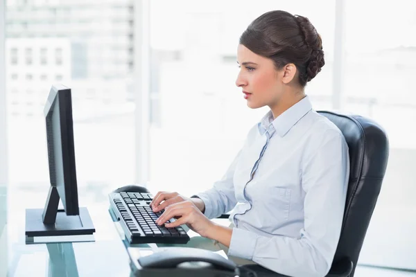 Empresária concentrada digitando em um computador — Fotografia de Stock