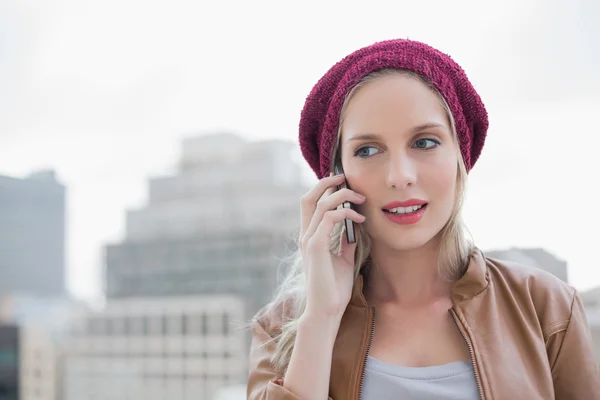 Casual blonde gericht op de telefoon buitenshuis — Stockfoto