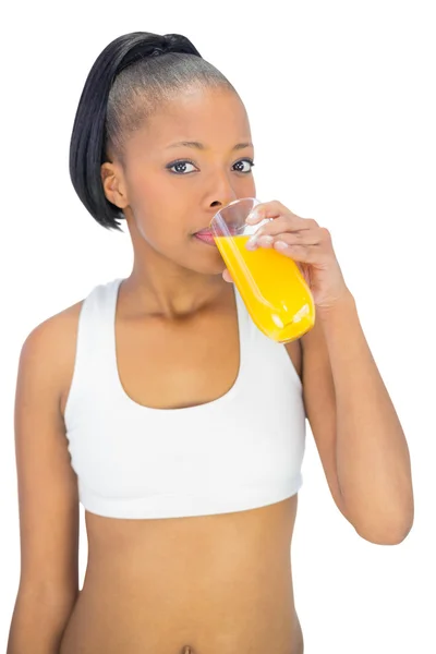 Mulher em sportswear beber copo de suco de laranja — Fotografia de Stock