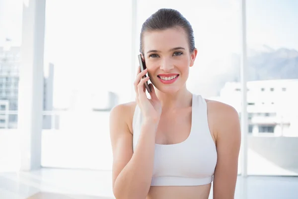 Modelo de ajuste agradable en ropa deportiva haciendo una llamada telefónica — Foto de Stock