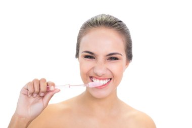 diş fırçası kullanarak gülümseyen genç kadın