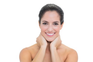 Boynunda iki elle dokunarak çıplak esmer gülümseyen