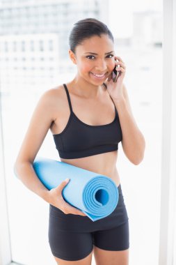 spor giyim taşıyan egzersiz minderi ve telefon görüşmesi model uygun