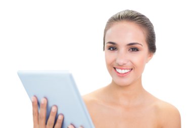 bir tablet tutan genç gülümseyen kadın