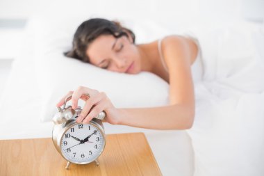 Sakin casual esmer beyaz pijamalı alarm saatini Torna
