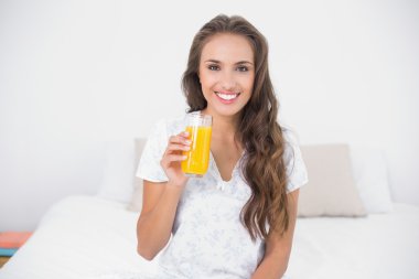 bir bardak portakal suyu tutan esmer