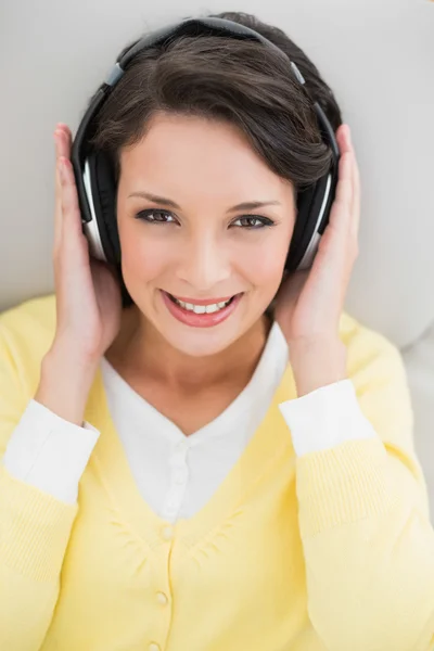 Cute casual brunette in yellow cardigan enjoying music — Stock Photo, Image