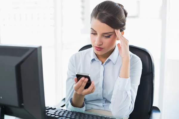 Besorgte Geschäftsfrau schaut auf ihr Handy — Stockfoto
