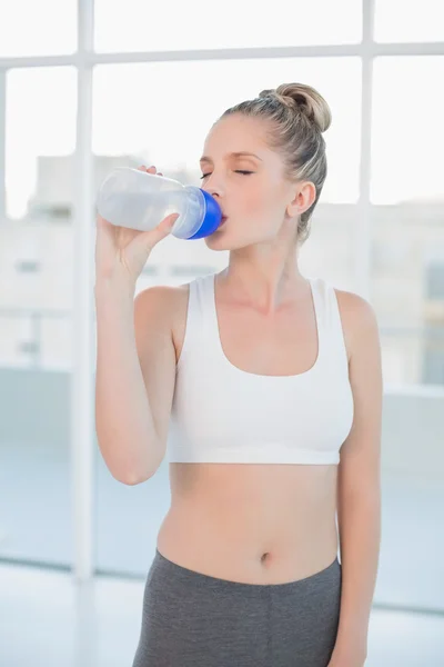 Fredliga sportig blondin dricksvatten efter träningen — Stockfoto