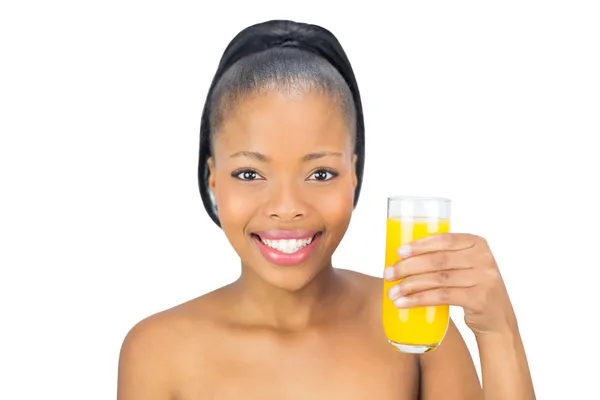 Mulher sorridente segurando suco de laranja de vidro — Fotografia de Stock