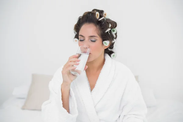 Friedliche natürliche Brünette trinkt Glas Wasser — Stockfoto