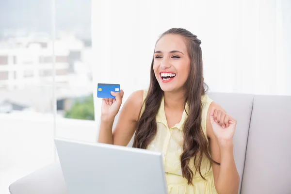 Victorious jovem morena segurando cartão de crédito — Fotografia de Stock