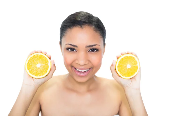 Joyful young model holding orange halves — Stock Photo, Image