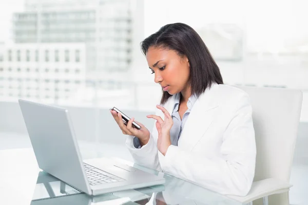 Ernstige jonge zakenvrouw met behulp van een mobiele telefoon — Stockfoto