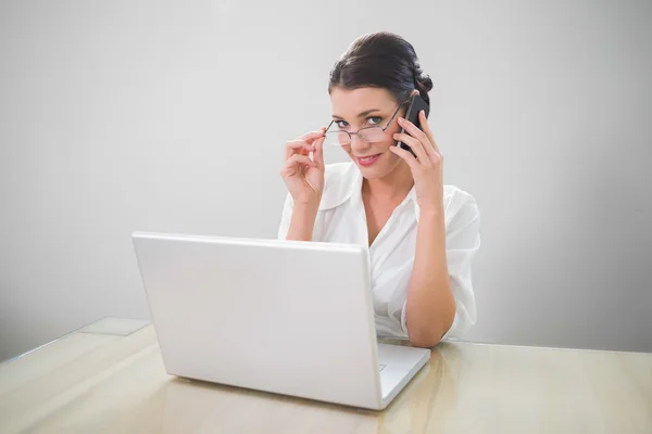 Mujer de negocios sonriente con gafas elegantes telefoneando —  Fotos de Stock