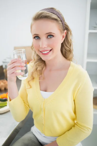 Joyeux blonde mignonne tenant un verre d'eau — Photo