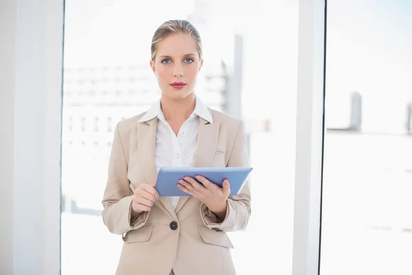 Ernsthafte blonde Geschäftsfrau mit Tablet-PC — Stockfoto