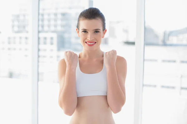 Content fit model in sportswear contracting her fists — Stock Photo, Image