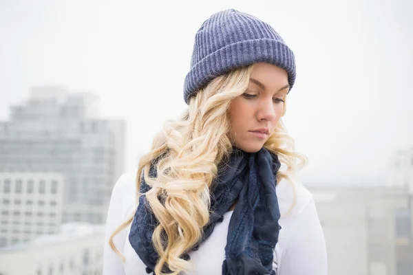 Doordachte blonde in winterkleren buitenshuis poseren — Stockfoto