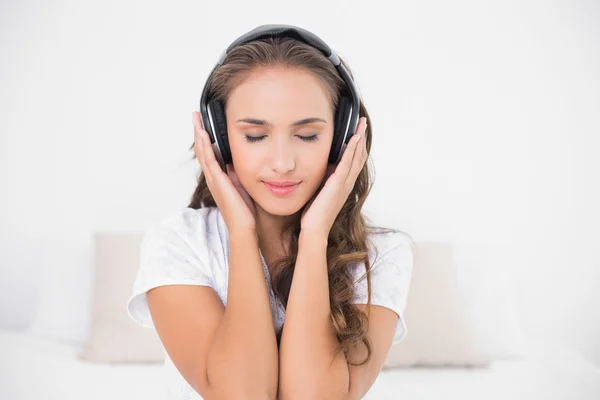 Brunette luisteren naar muziek met gesloten ogen — Stockfoto