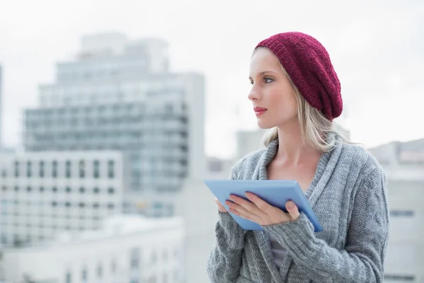 Mooie blonde denken buiten de tablet pc gebruiken — Stockfoto