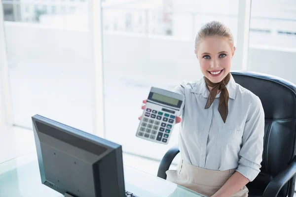 Blonde lächelnde Geschäftsfrau zeigt Taschenrechner — Stockfoto