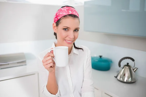 Femme charmante souriante tenant une tasse de thé — Photo