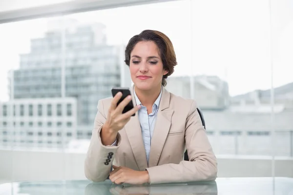 Empresária sorrindo para seu smartphone — Fotografia de Stock