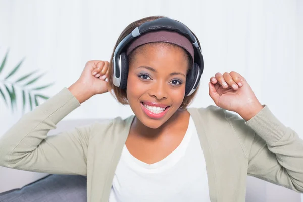 Mulher dançando ouvir música com fones de ouvido enquanto olha para a câmera — Fotografia de Stock