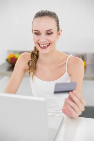 Mujer joven emocionada utilizando su ordenador portátil para las compras en línea —  Fotos de Stock