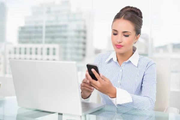 Content brunette businesswoman looking at smartphone — Stock Photo, Image