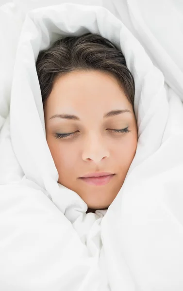 Peaceful casual brunette wrapped up in her duvet — Stock Photo, Image