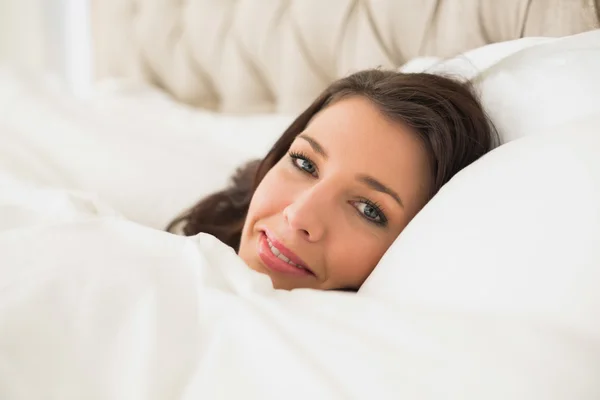 Lächelnde hübsche Frau entspannt sich in ihrem Bett — Stockfoto