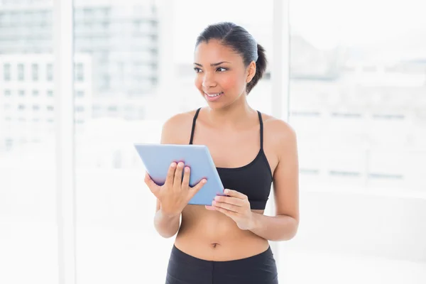 Thinking model in sportswear holding a tablet pc — Stock Photo, Image
