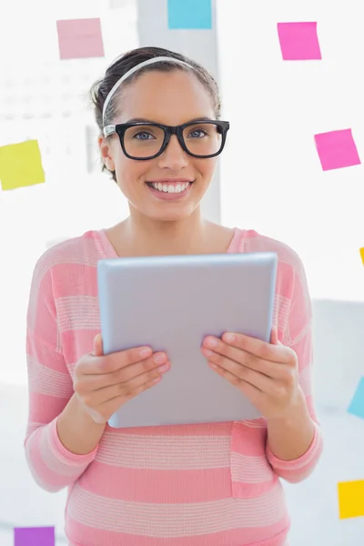 Sonriente artista sosteniendo la tableta y mirando a la cámara — Foto de Stock