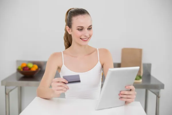 Mujer joven feliz usando su tableta para ir de compras en línea —  Fotos de Stock