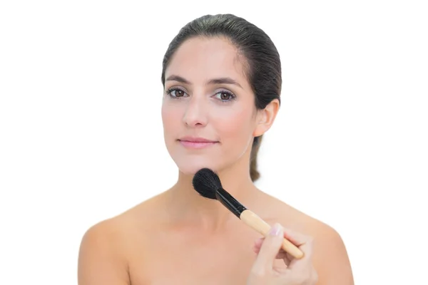 Calm bare brunette holding powder brush — Stock Photo, Image