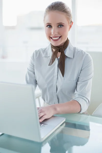 Blonde vrolijke zakenvrouw met behulp van laptop — Stockfoto