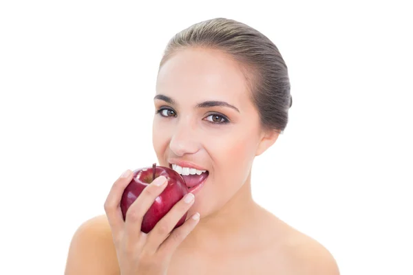 Content young woman biting in a red apple — Stock Photo, Image