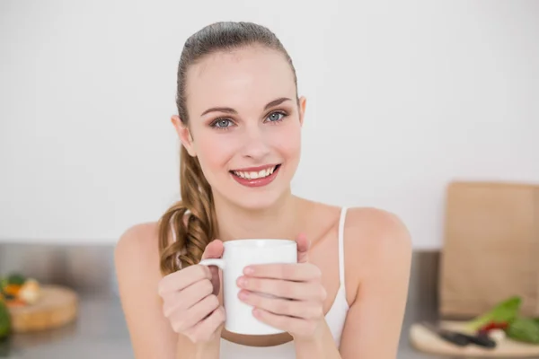 Vrolijke jonge vrouw bedrijf mok — Stockfoto