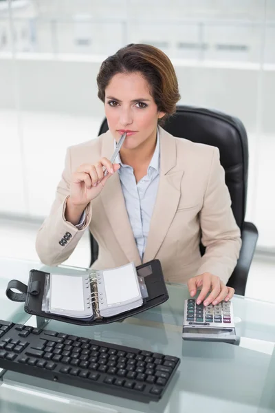 Femme d'affaires réfléchie en utilisant une calculatrice — Photo